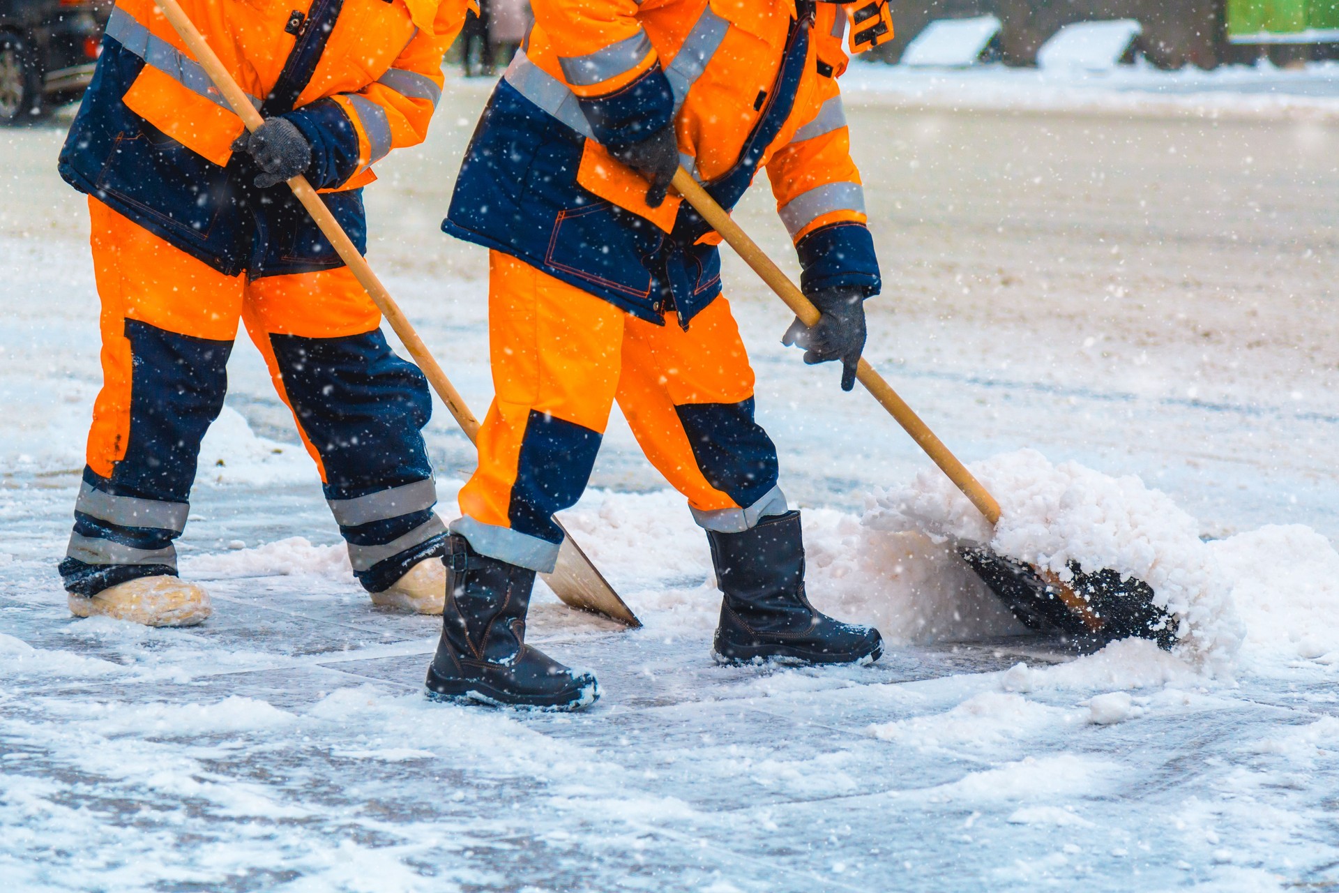 I lavoratori dei servizi comunali spazzano via la neve dalla strada in inverno, pulendo le strade e le strade della città durante la tempesta di neve. Mosca, Russia.